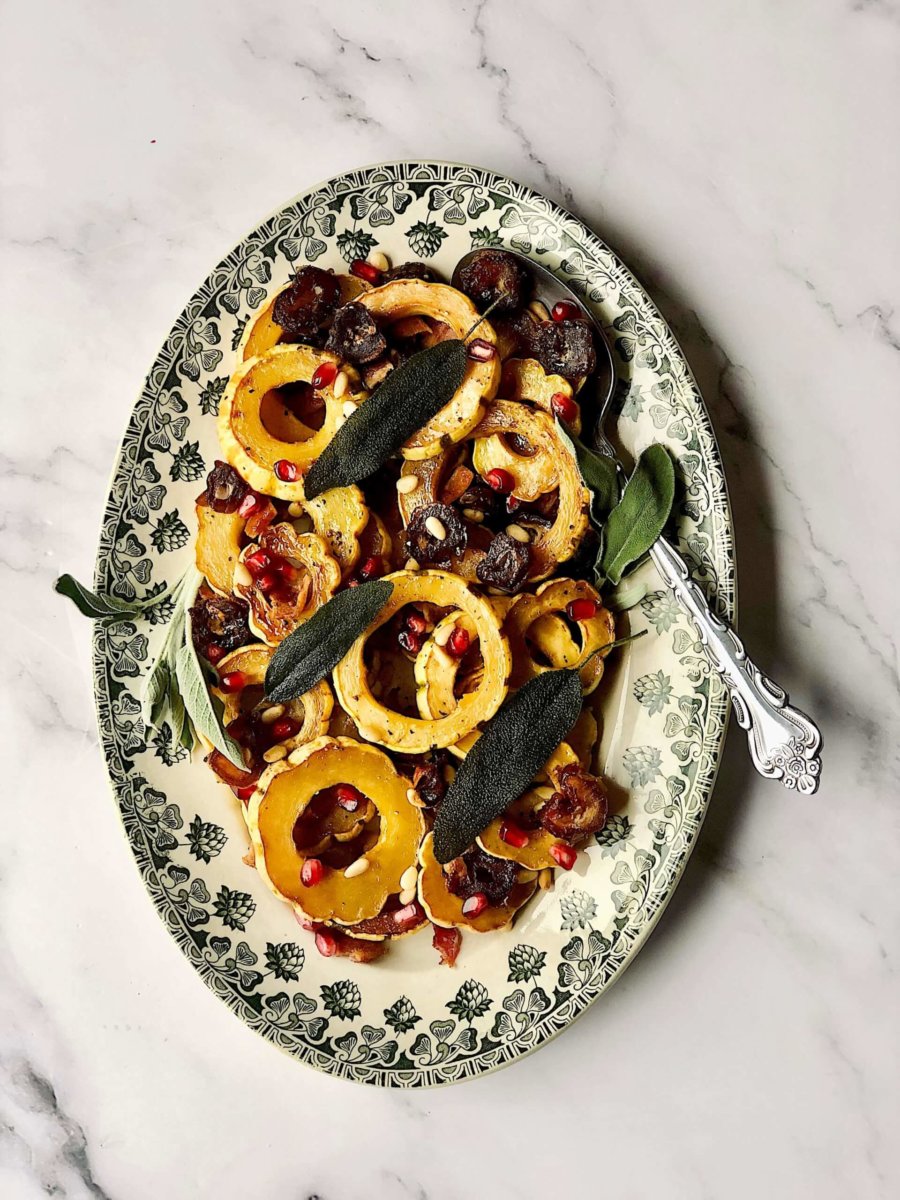 This is a photo of sliced delicata squash, date coins, pine nuts, bacon and fried sage