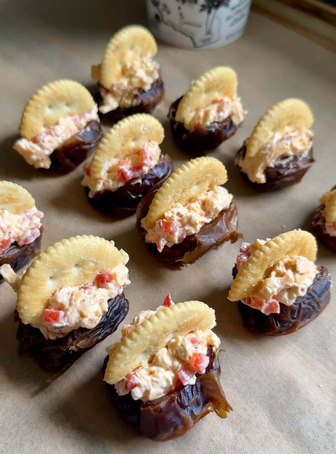 rows of dates filled with pimento cheese and topped with a ritz cracker